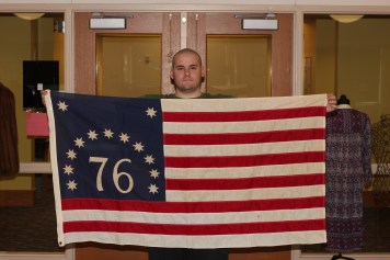 Student worker, Josh Knecht, holding a American Bicentennial flag from the Ken McCutchan collection, 1976. Credit: James Wethington