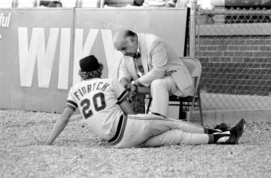 Man talking to Mark "the Bird" Fidrych as he sits on the ground at Bosse Field. He played for the AAA Evansville Triplets of the American Association in 1975 before being called up to the Detroit Tigers, 1976. Source: Gregory Smith Collection, MSS 034-1300.