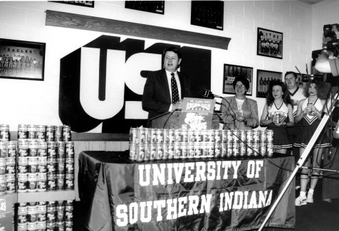 (Left to Right): Dr. H. Ray Hoops, Sherrianne Standley, and USI cheerleaders introducing Screaming Eagles soda, 1995. Source : University Archives and Special Collections, UP 05305.