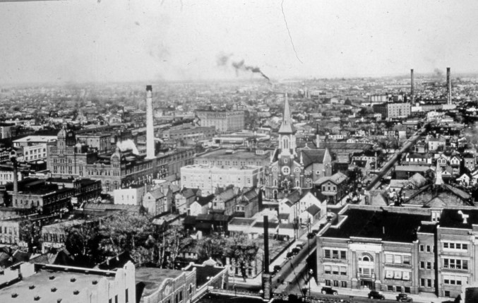 This 1920s image, looking down on the central part of Evansville, gives some idea of what had to be removed for the Civic Center to be built. The smokestack just left is center is Cook Brewery, and the church in the center is Assumption Catholic Church. Both were razed for the Civic Center. Source: Darrell Bigham Collection MSS 181-1271.